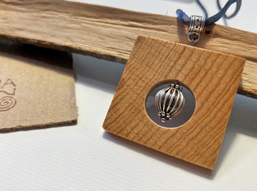 Handmade square wooden pendant with a silver bead inlay. Beech, silver
