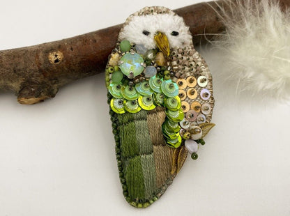 This handmade brooch features an owl design with a beige base, and shades of green colors - Ornamentico shop