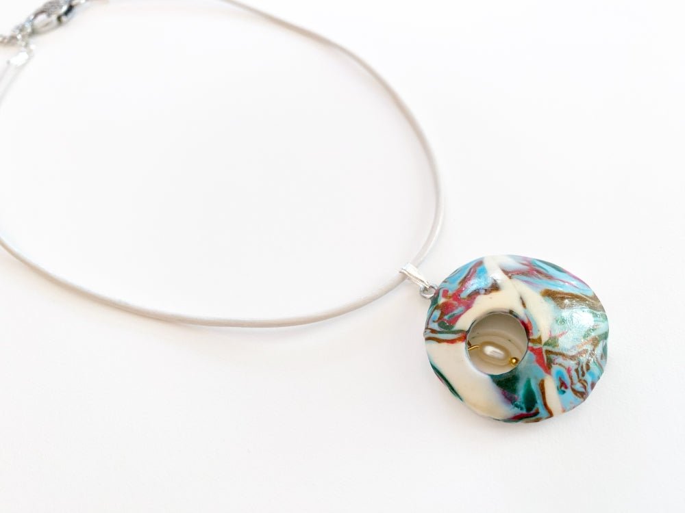 Unique pendant crafted from custom polymer clay marble mix featuring curved front and a small pearl inside - Ornamentico shop